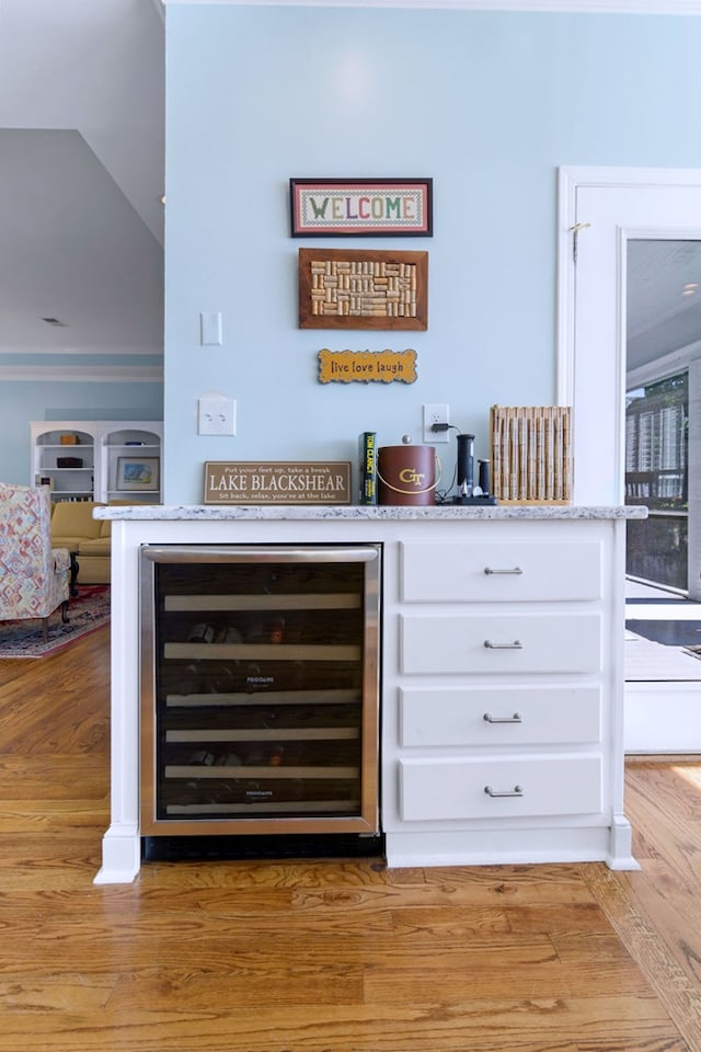 bar featuring light wood-style floors and beverage cooler