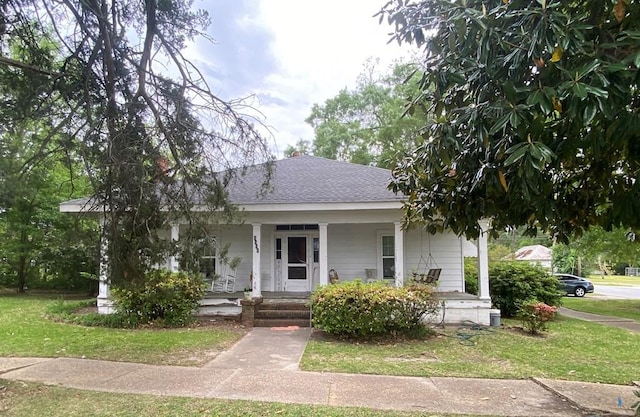 view of front of home with covered porch and a front lawn