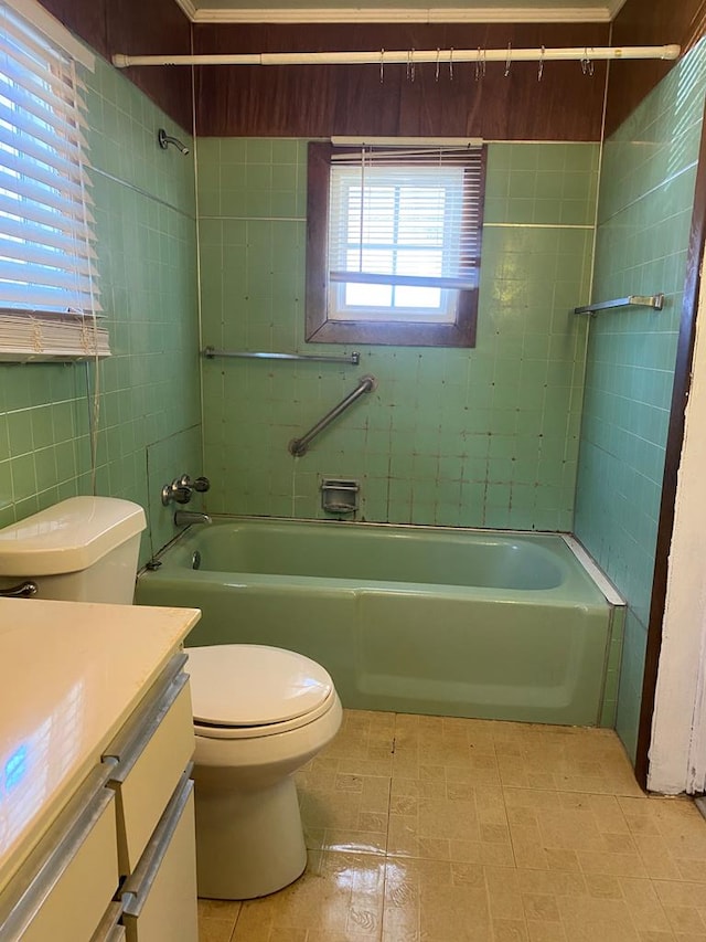 full bathroom with vanity, tiled shower / bath, tile walls, and toilet