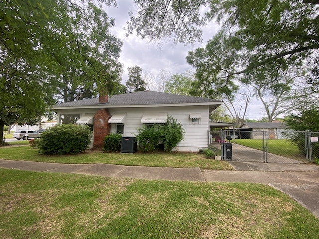 view of front facade featuring cooling unit and a front lawn