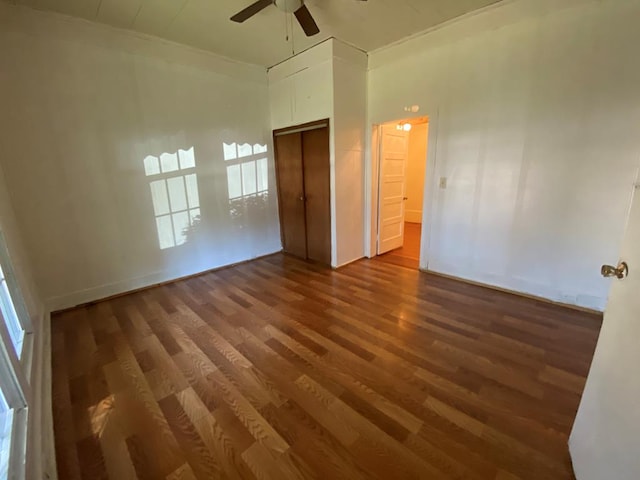 unfurnished bedroom featuring ceiling fan, dark hardwood / wood-style flooring, and a closet