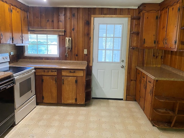 kitchen featuring ornamental molding, black dishwasher, white electric range oven, and wood walls