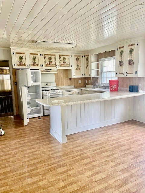 kitchen with kitchen peninsula, white appliances, light hardwood / wood-style floors, and wood ceiling