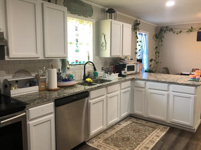 kitchen with white cabinetry, appliances with stainless steel finishes, sink, and light stone countertops