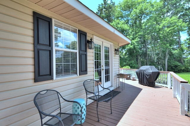 wooden terrace featuring french doors and a grill