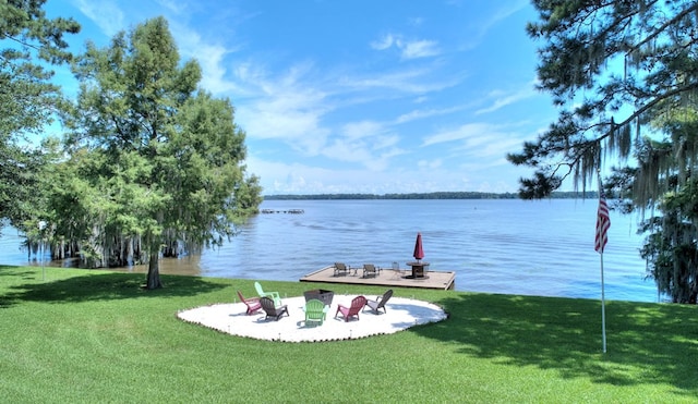 view of dock featuring a lawn and a water view