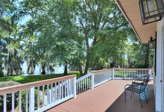 wooden terrace featuring a lawn and a water view