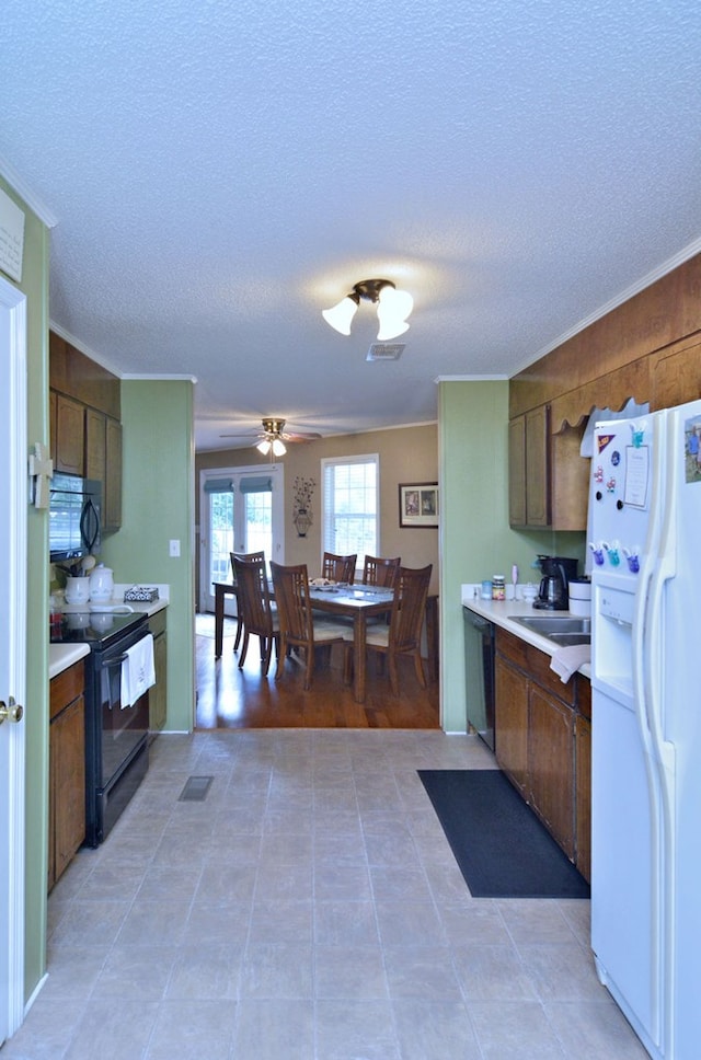 kitchen featuring ceiling fan, sink, a textured ceiling, and black appliances