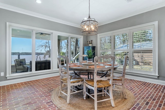 dining room with a water view, brick floor, plenty of natural light, and ornamental molding