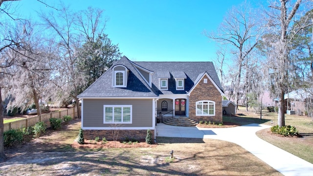 view of front of property featuring a front yard, concrete driveway, roof with shingles, and fence