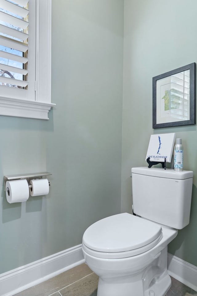 bathroom featuring baseboards and toilet