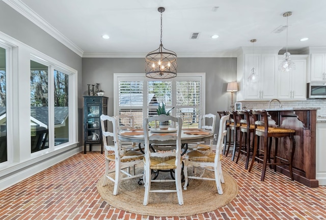 dining space with visible vents, brick floor, an inviting chandelier, crown molding, and recessed lighting