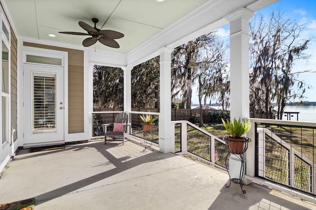 unfurnished sunroom featuring a water view and a ceiling fan