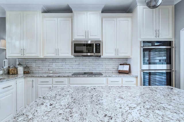 kitchen with white cabinets, light stone countertops, stainless steel appliances, and decorative backsplash