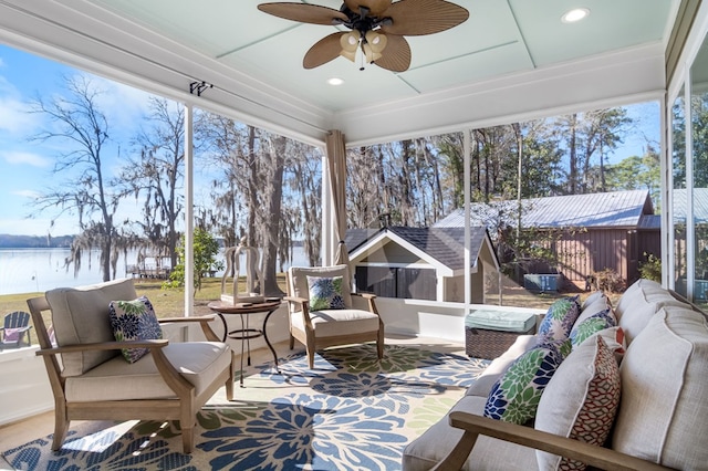 sunroom with ceiling fan, a water view, and a wealth of natural light