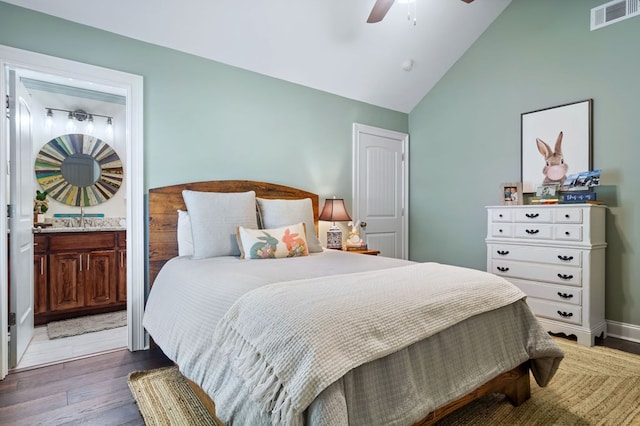 bedroom featuring dark wood-style floors, visible vents, connected bathroom, vaulted ceiling, and ceiling fan