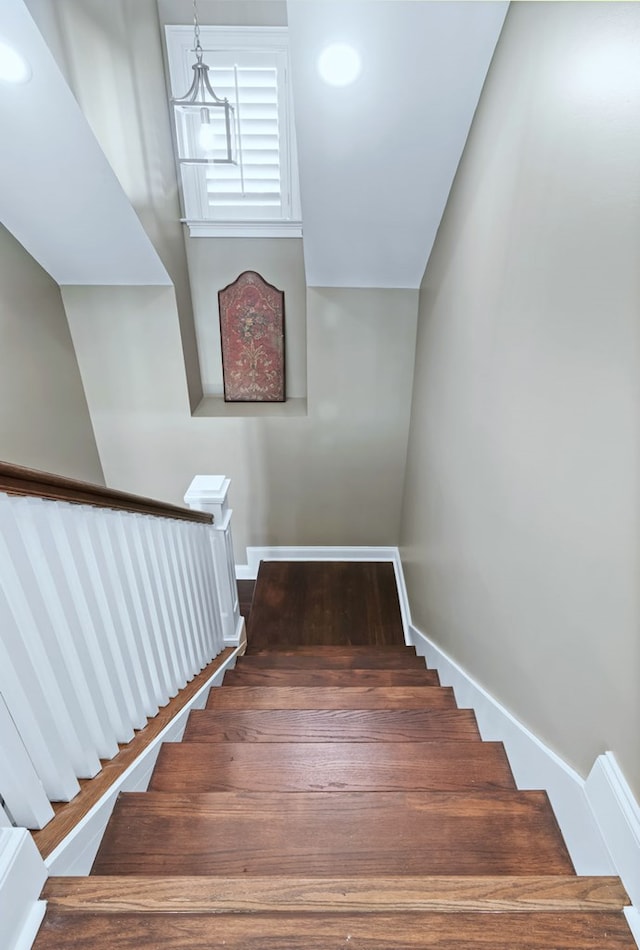 stairs featuring wood finished floors and baseboards