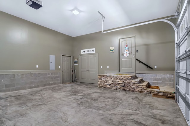 garage featuring concrete block wall and electric panel