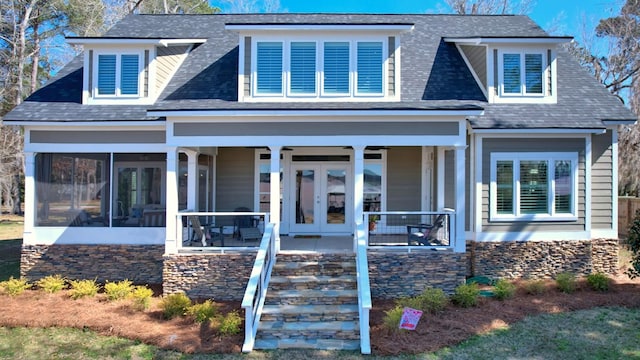 view of front of home with a sunroom, french doors, and covered porch