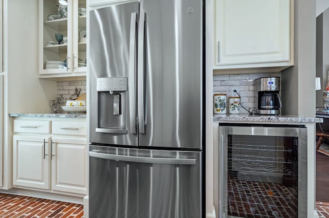 kitchen with wine cooler, backsplash, glass insert cabinets, white cabinets, and stainless steel fridge