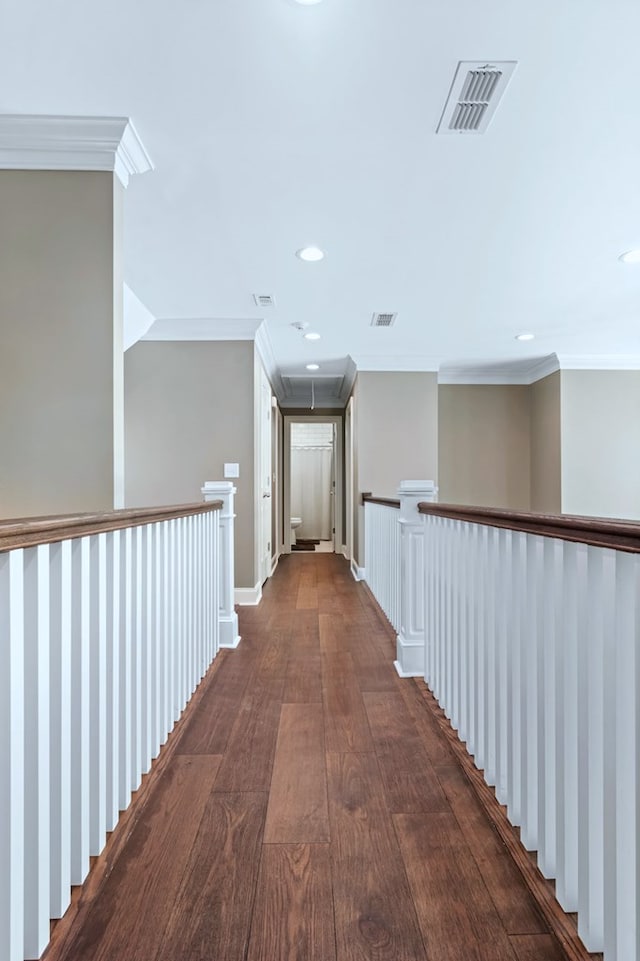 hallway featuring visible vents, dark wood-type flooring, and crown molding