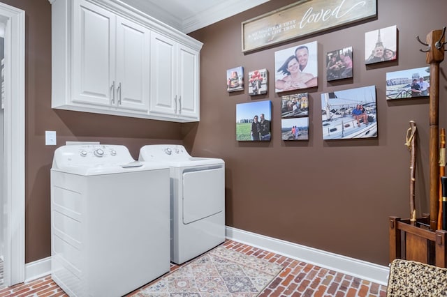 clothes washing area featuring brick floor, cabinet space, ornamental molding, washing machine and dryer, and baseboards