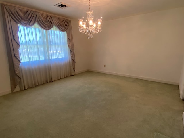 unfurnished room featuring carpet and a chandelier