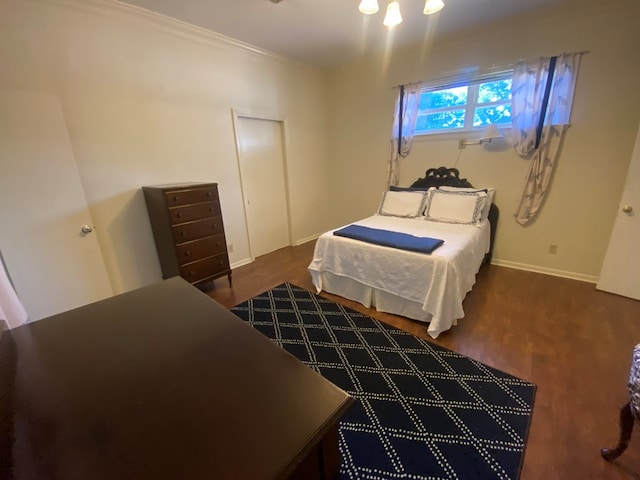 bedroom with dark wood-type flooring and crown molding