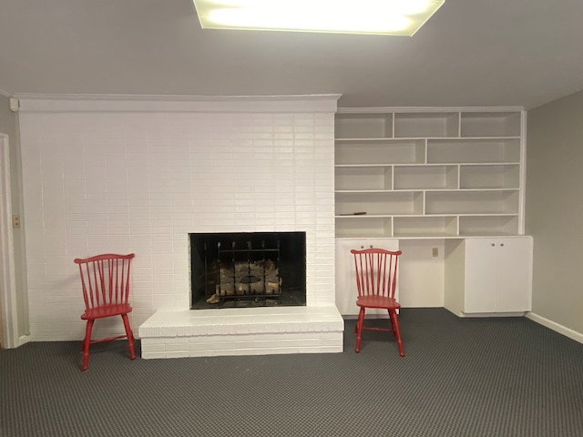 living area featuring dark colored carpet, ornamental molding, and a fireplace