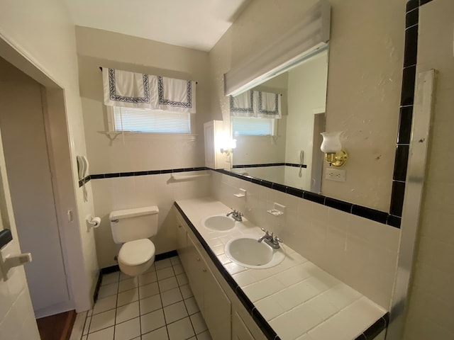 bathroom with toilet, a healthy amount of sunlight, tile walls, and tile patterned flooring