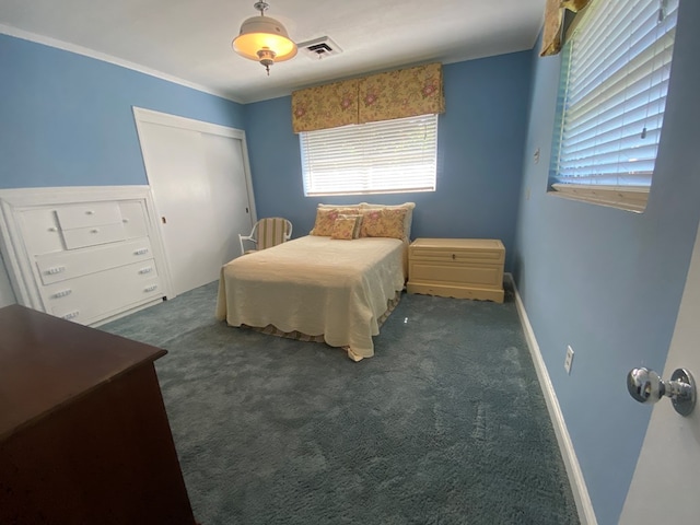 bedroom featuring a closet, dark carpet, and ornamental molding