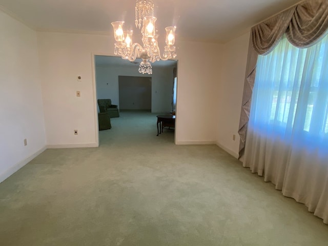 carpeted empty room with an inviting chandelier