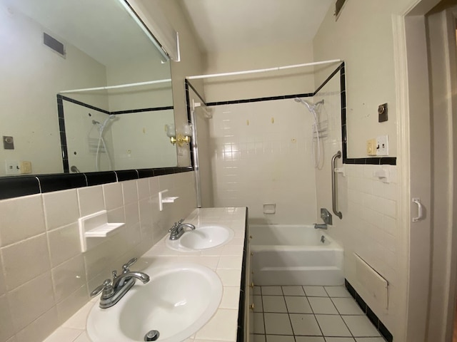 bathroom with tasteful backsplash, tiled shower / bath, tile patterned flooring, and tile walls