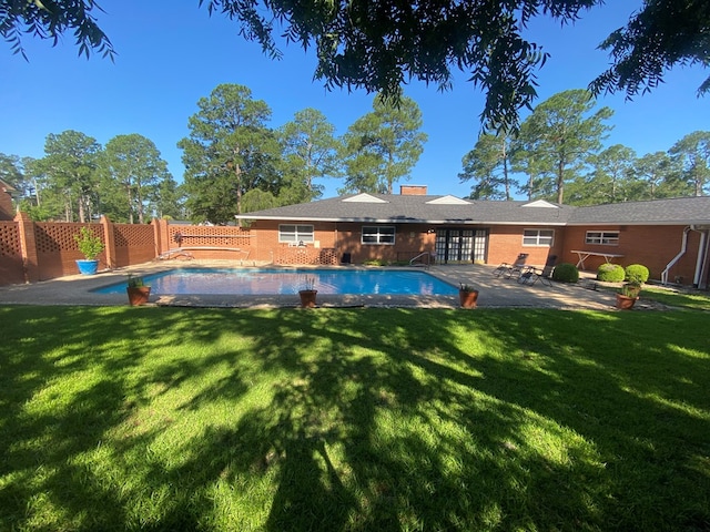 view of pool with a patio area and a lawn