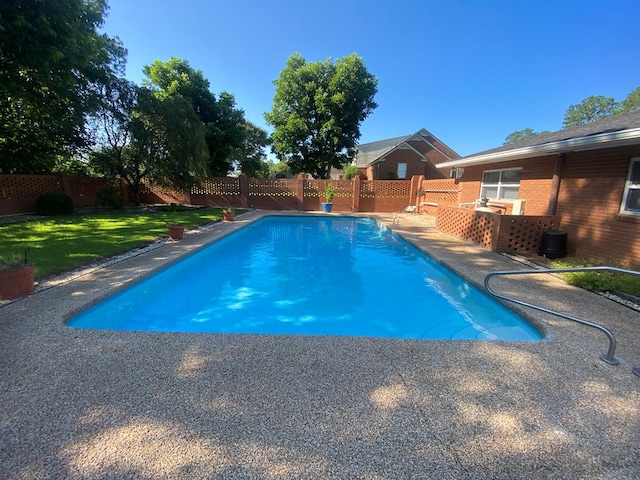 view of swimming pool featuring a yard