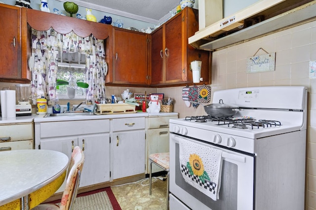 kitchen featuring ornamental molding, white gas range, a textured ceiling, and white cabinets