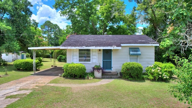 view of front of property with a carport and a front lawn