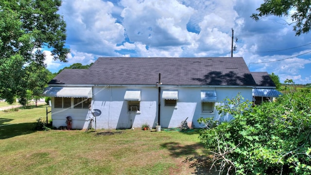 rear view of house featuring a lawn