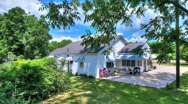 back of house featuring a lawn and a patio area