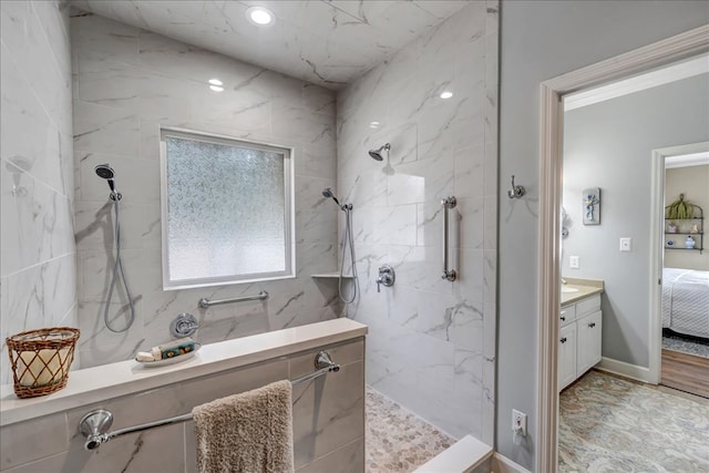 bathroom with tiled shower and vanity