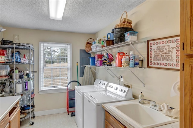 laundry area with sink, washer and clothes dryer, cabinets, and a textured ceiling