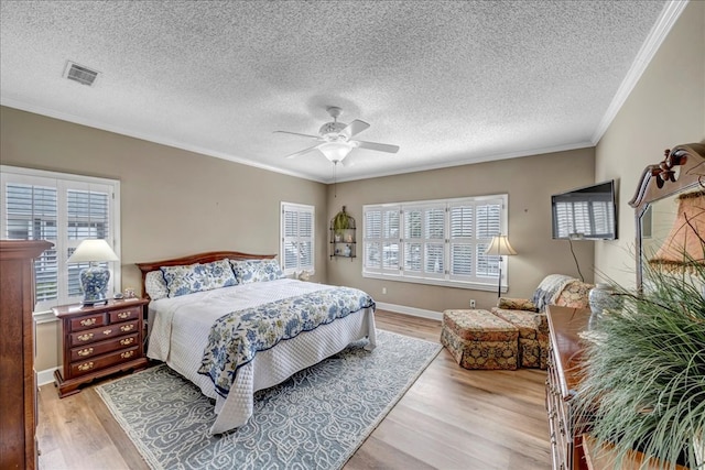 bedroom featuring multiple windows, crown molding, and light hardwood / wood-style floors