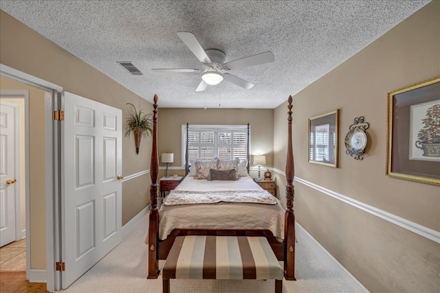 carpeted bedroom with ceiling fan and a textured ceiling