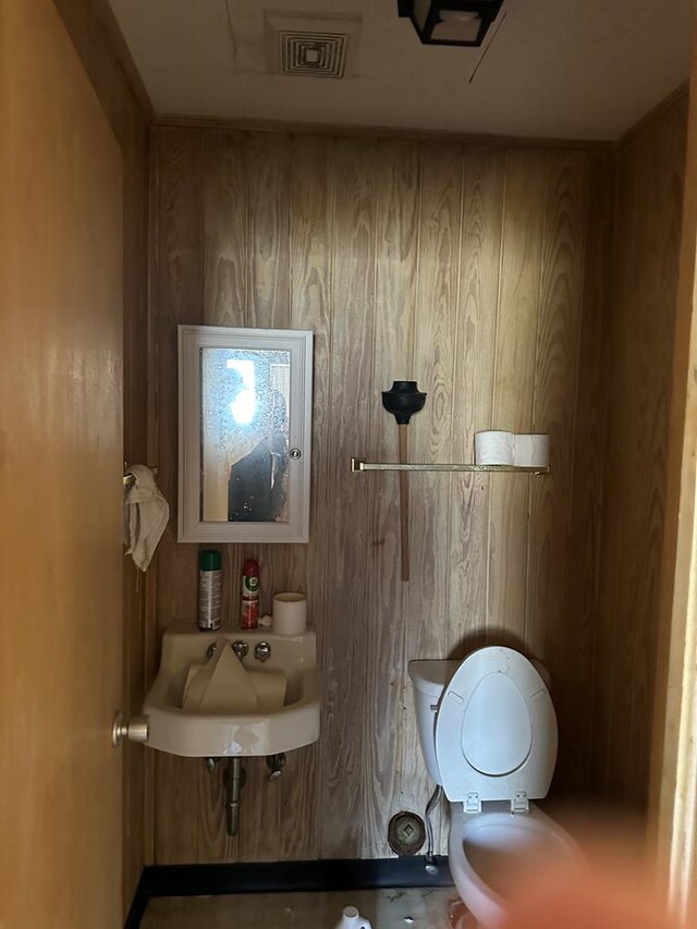 bathroom with toilet and wooden walls