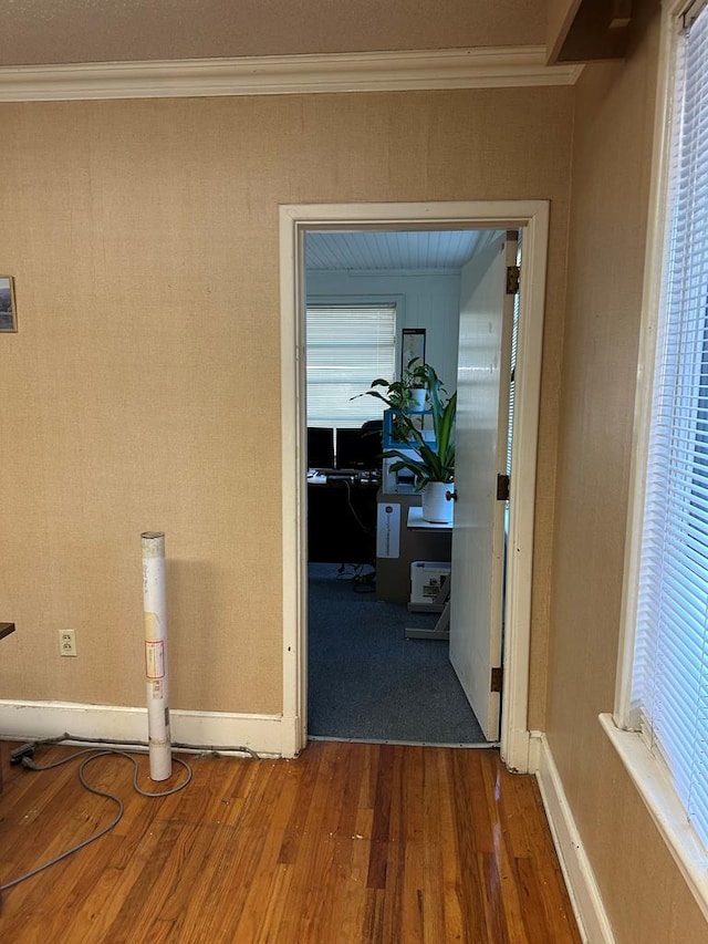 corridor with hardwood / wood-style floors and crown molding