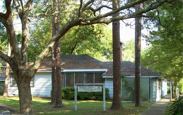 view of side of home with a yard