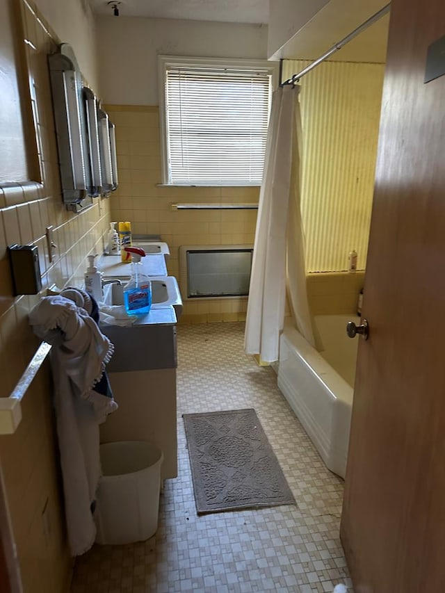 bathroom featuring shower / bath combo, decorative backsplash, tile walls, and vanity