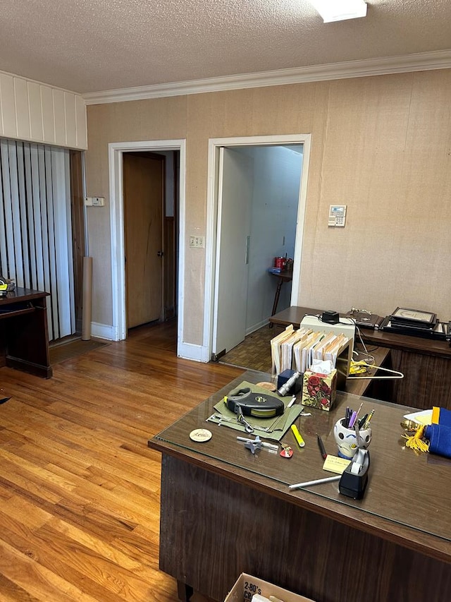 office space with hardwood / wood-style flooring, a textured ceiling, and ornamental molding