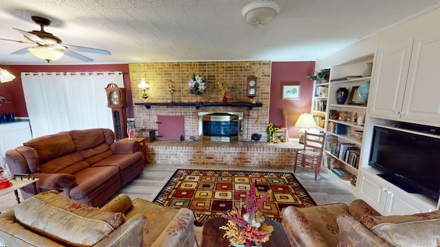 living room featuring light hardwood / wood-style floors, ceiling fan, and a fireplace