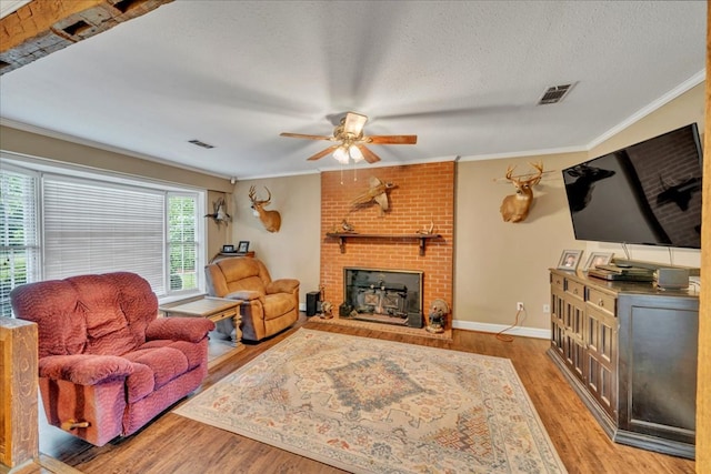 2489 W Ga Highway 30, Americus, GA 31719 - living area featuring ceiling fan, wood finished floors, a fireplace, crown molding, and baseboards